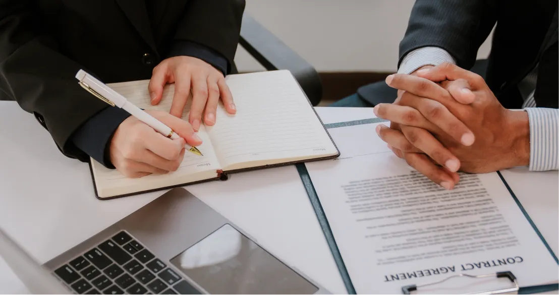 Professional agent taking notes during a consultation for a senior life insurance contract agreement - Senior Life Insurance